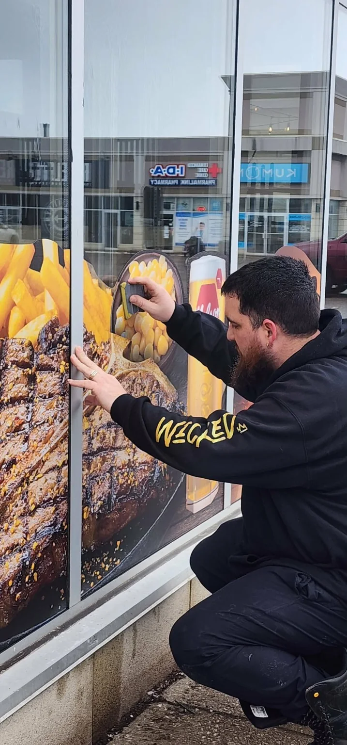 Wicked installer applying a commercial wall mural graphic
